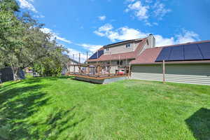 Rear view of house featuring a yard and a deck