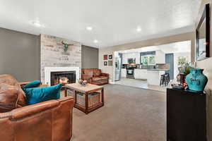 Carpeted living room featuring a large fireplace.