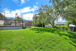 View of yard with a deck with mountain view