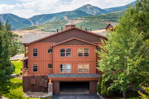 View of front of property with a mountain view and a garage