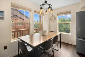 Dining room featuring a wealth of natural light, dark hardwood / wood-style floors, and a chandelier