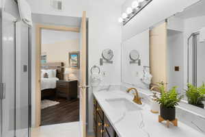 Bathroom featuring hardwood / wood-style floors, an enclosed shower, and vanity