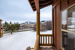 Snow covered back of property with a mountain view