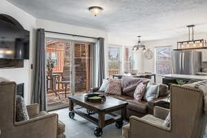 Living room featuring a textured ceiling and an inviting chandelier