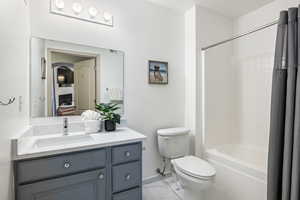 Full bathroom featuring tile patterned flooring, vanity, shower / tub combo, and toilet