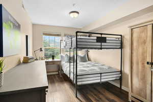 Bedroom with a textured ceiling and dark hardwood / wood-style floors