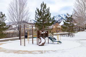 Snow covered playground with a mountain view