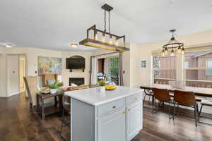 Kitchen featuring decorative light fixtures, a center island, and dark hardwood / wood-style floors