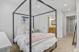 Carpeted bedroom featuring ceiling fan, sink, and connected bathroom