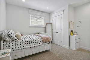 Bedroom with a textured ceiling, a closet, and carpet flooring