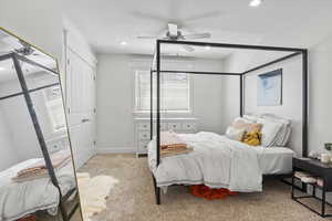 Bedroom featuring ceiling fan, a textured ceiling, and light colored carpet