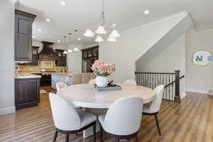 Dining area featuring sink, ornamental molding, an inviting chandelier, and dark hardwood / wood-style floors