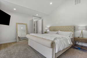 Bedroom with carpet floors and vaulted ceiling