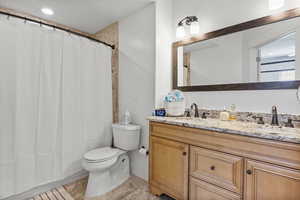 Bathroom with tile patterned floors, a shower with shower curtain, vanity, and toilet