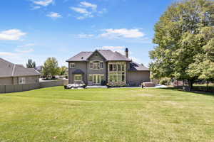 Back of property with a patio, a lawn, and a hot tub