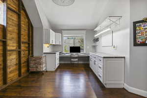 Kitchen featuring white cabinets, vaulted ceiling, and dark hardwood / wood-style floors