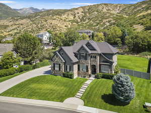 View of front of home with a mountain view and a front yard