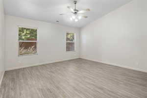 Empty room featuring light hardwood / wood-style flooring, ceiling fan, and plenty of natural light