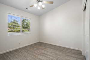 Spare room with ceiling fan, vaulted ceiling, and hardwood / wood-style flooring