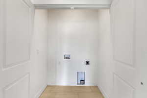 Laundry area featuring light tile patterned flooring, hookup for a washing machine, and electric dryer hookup