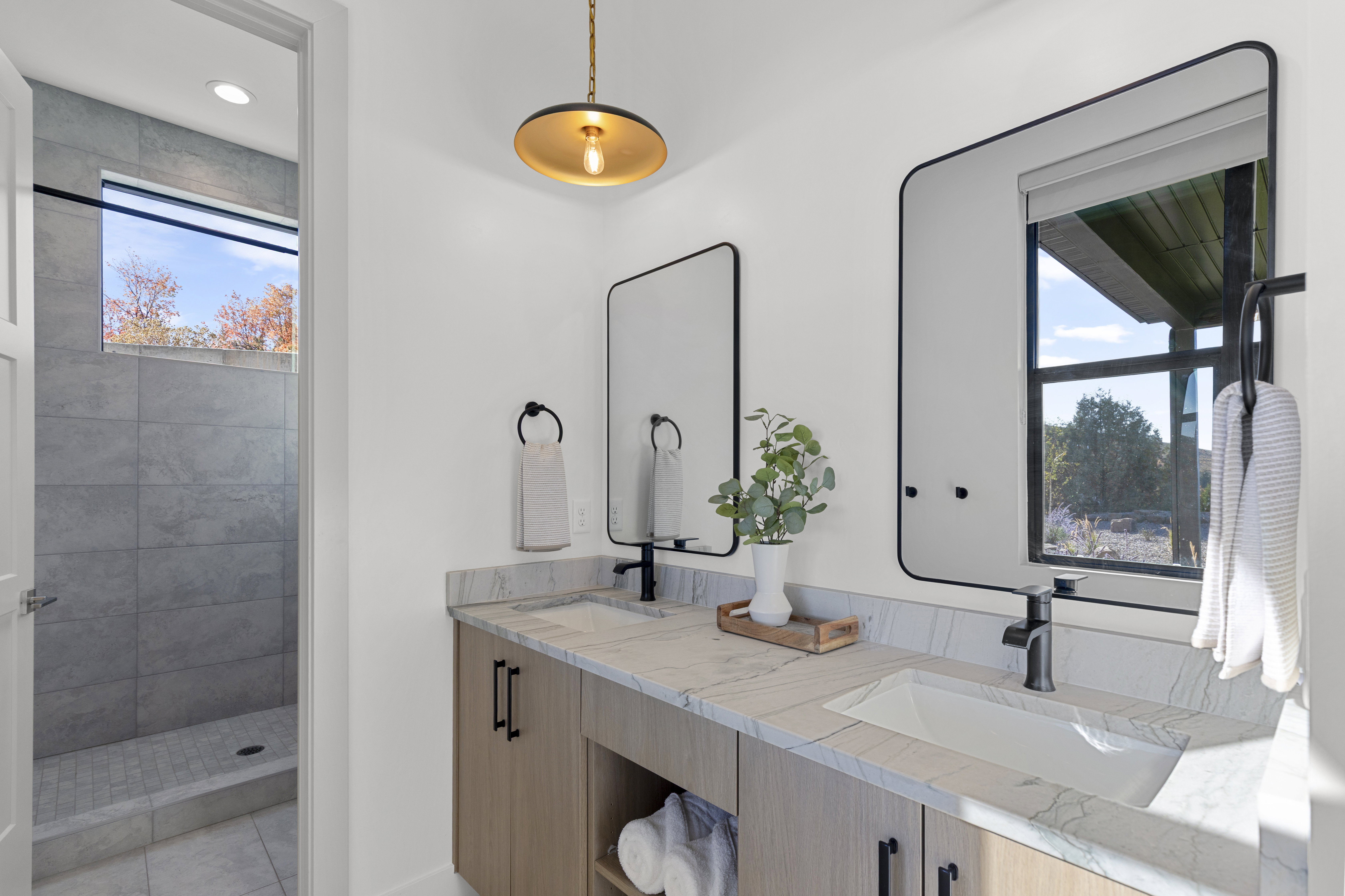 Full bath with double vanity and tiled shower
