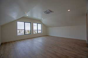 Bonus room with vaulted ceiling and hardwood / wood-style floors