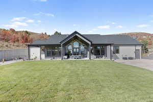 Back of property with a lawn and a patio area