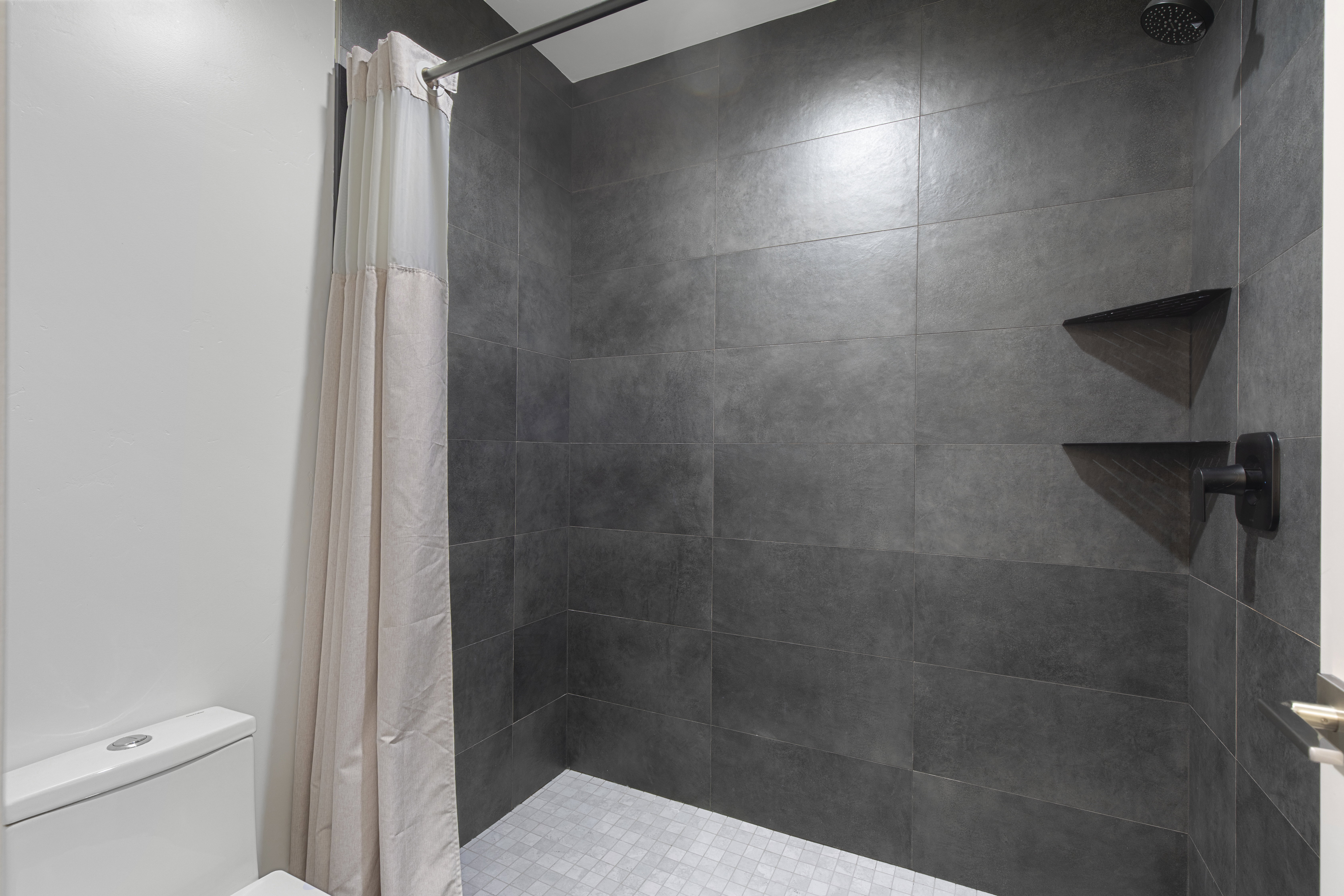 Bathroom featuring a shower stall and toilet