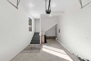 Stairs featuring unfinished concrete flooring