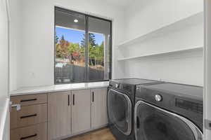 Laundry room with washing machine and dryer and light wood-type flooring