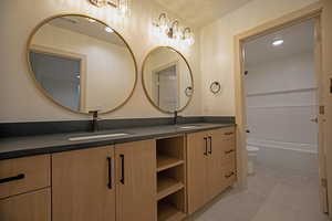 Full bathroom with washtub / shower combination, vanity, and toilet
