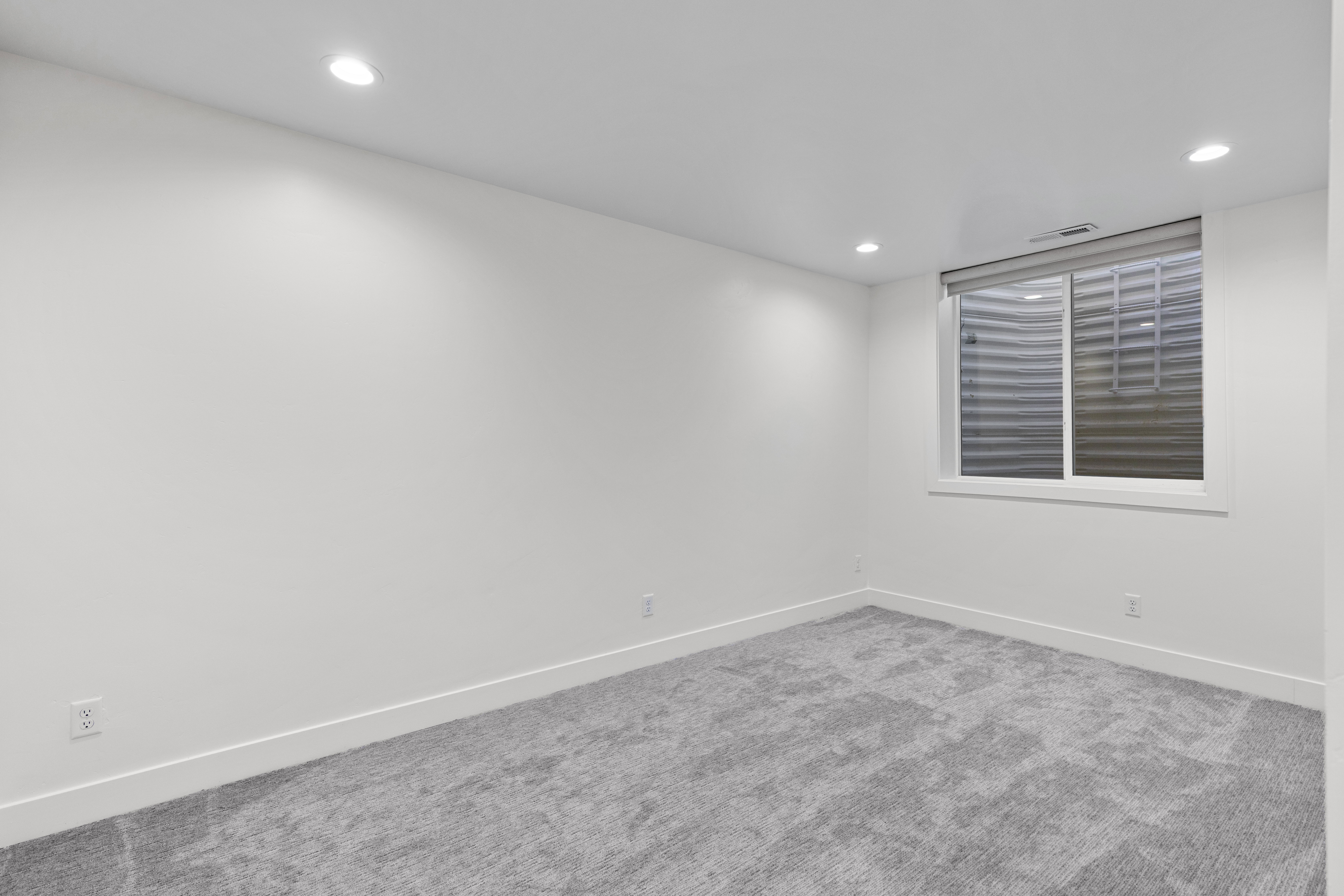 Carpeted empty room with baseboards and recessed lighting