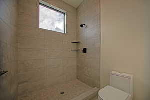 Bathroom featuring toilet and tiled shower
