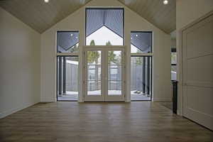 Doorway to outside featuring lofted ceiling and plenty of natural light