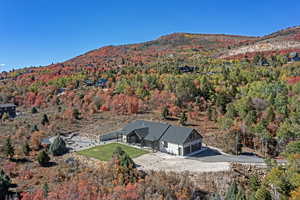 View of subject property featuring a mountain backdrop and a heavily wooded area