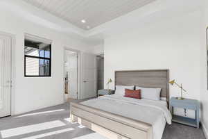 Carpeted bedroom with a raised ceiling, recessed lighting, and wood ceiling