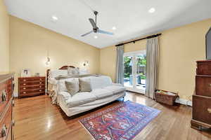 Bedroom with ceiling fan, access to exterior, and hardwood / wood-style floors