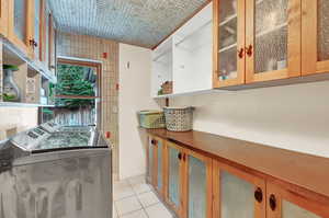 Interior space with tile walls, light tile patterned floors, and washing machine and clothes dryer