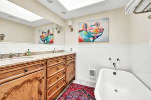 Bathroom featuring vanity, tasteful backsplash, tile patterned floors, tile walls, and a bathing tub