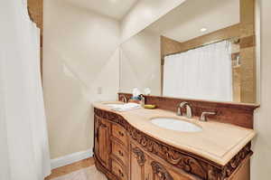 Bathroom with tile patterned flooring, vanity, and walk in shower