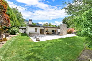 Back of house featuring a patio area and a lawn