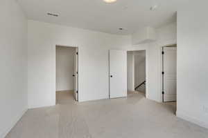 Unfurnished bedroom with light colored carpet