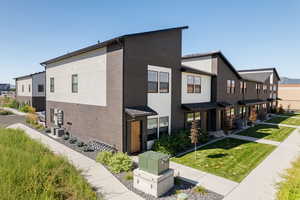 View of side of home featuring central AC unit and a yard