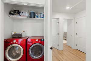 Washroom featuring hardwood / wood-style floors and washing machine and clothes dryer