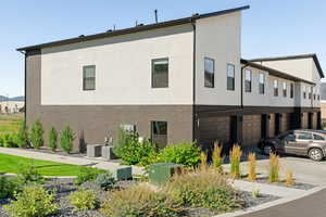 View of side of home featuring central AC unit and a garage