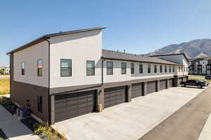 Exterior space featuring a mountain view, central AC unit, and a garage