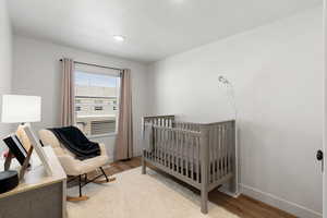 Bedroom with hardwood / wood-style floors and a crib