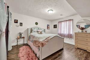 Bedroom featuring a textured ceiling and dark hardwood / wood-style floors