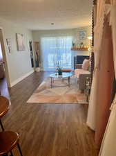 Living room with dark hardwood / wood-style flooring and a textured ceiling