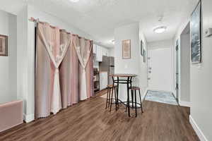 Dining space with dark hardwood / wood-style floors and a textured ceiling